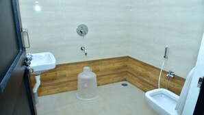 A small bathroom with a sink, a bidet, and a toilet.