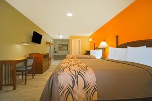 Een hotelkamer met een bed, bureau, stoel en een aan de muur bevestigde televisie.
