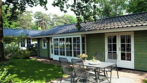 A house with a patio, a dining table with chairs, and a small garden area. - Fin Maison Sauna 4 (Belfeld)