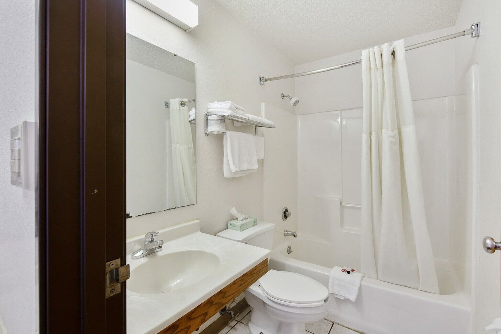 A bathroom with a sink, toilet, and shower.
