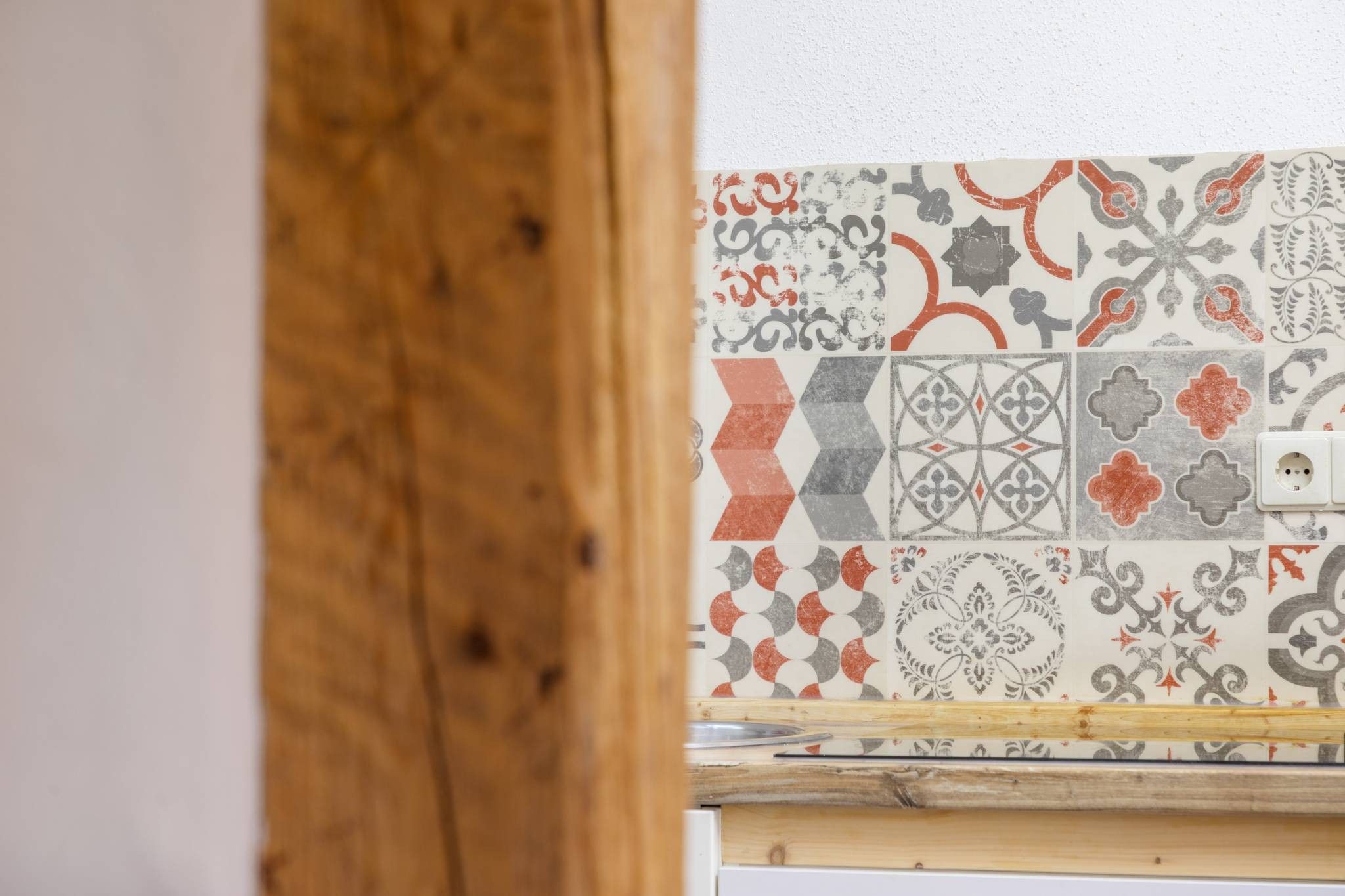 Ein Ausschnitt eines Raumes mit Holzelementen und einer Kachelwand.