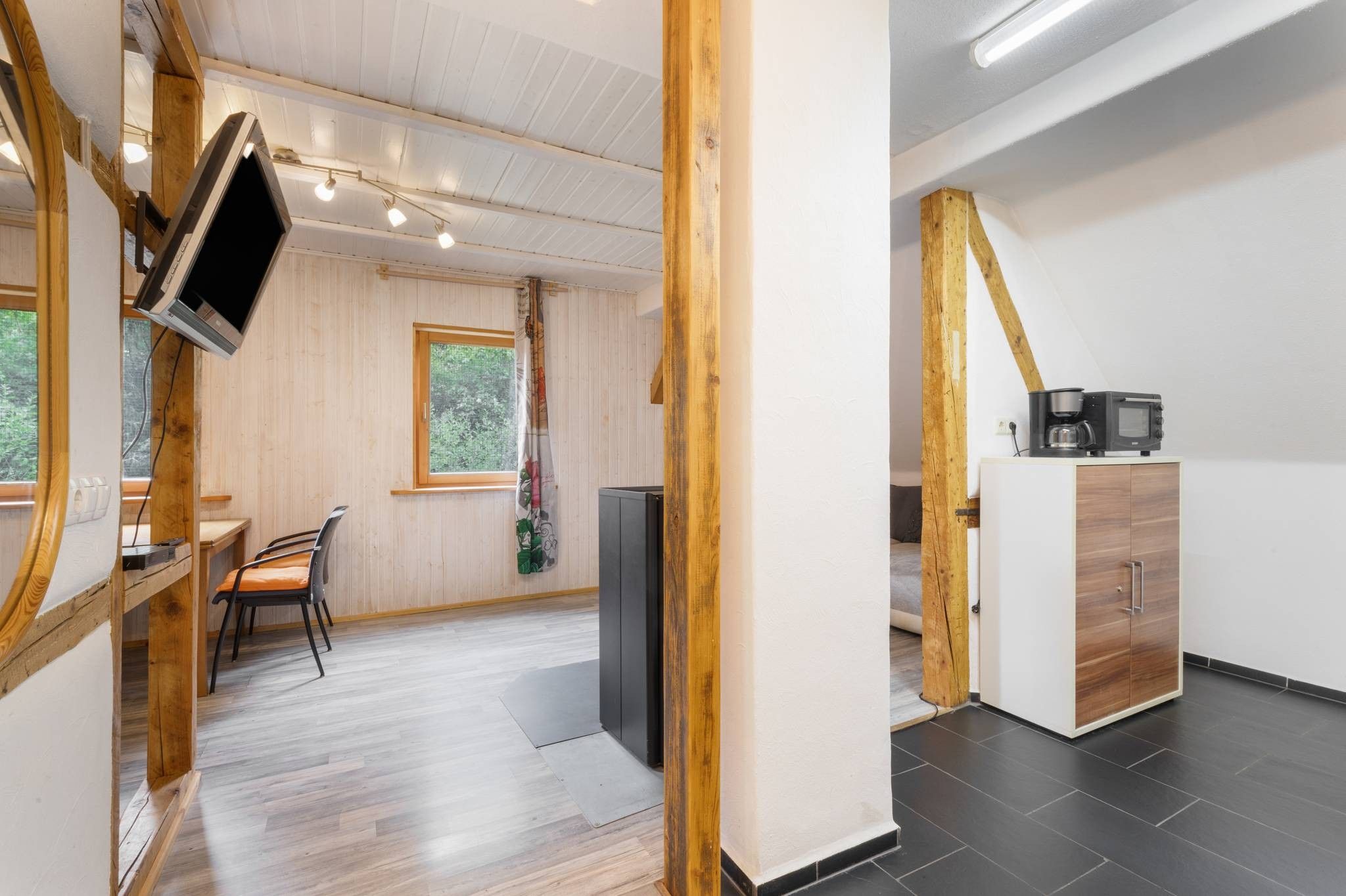 Ein modernes Interieur mit Essbereich, Küche und einem großen Fenster.