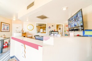 A reception desk with a computer monitor, a fire extinguisher, and a bulletin board.