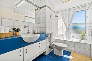 Un bagno moderno con un piano di lavoro blu, un lavandino bianco e un water.