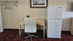 A small room with a desk, chair, and a white refrigerator. - King Bed Accessible Non-Smoking (Chickamauga)