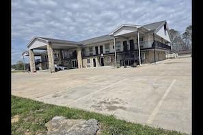 A multi-story hotel with a covered parking area and a stone facade. - King Bed|Smoking|Chickamauga (Chickamauga)