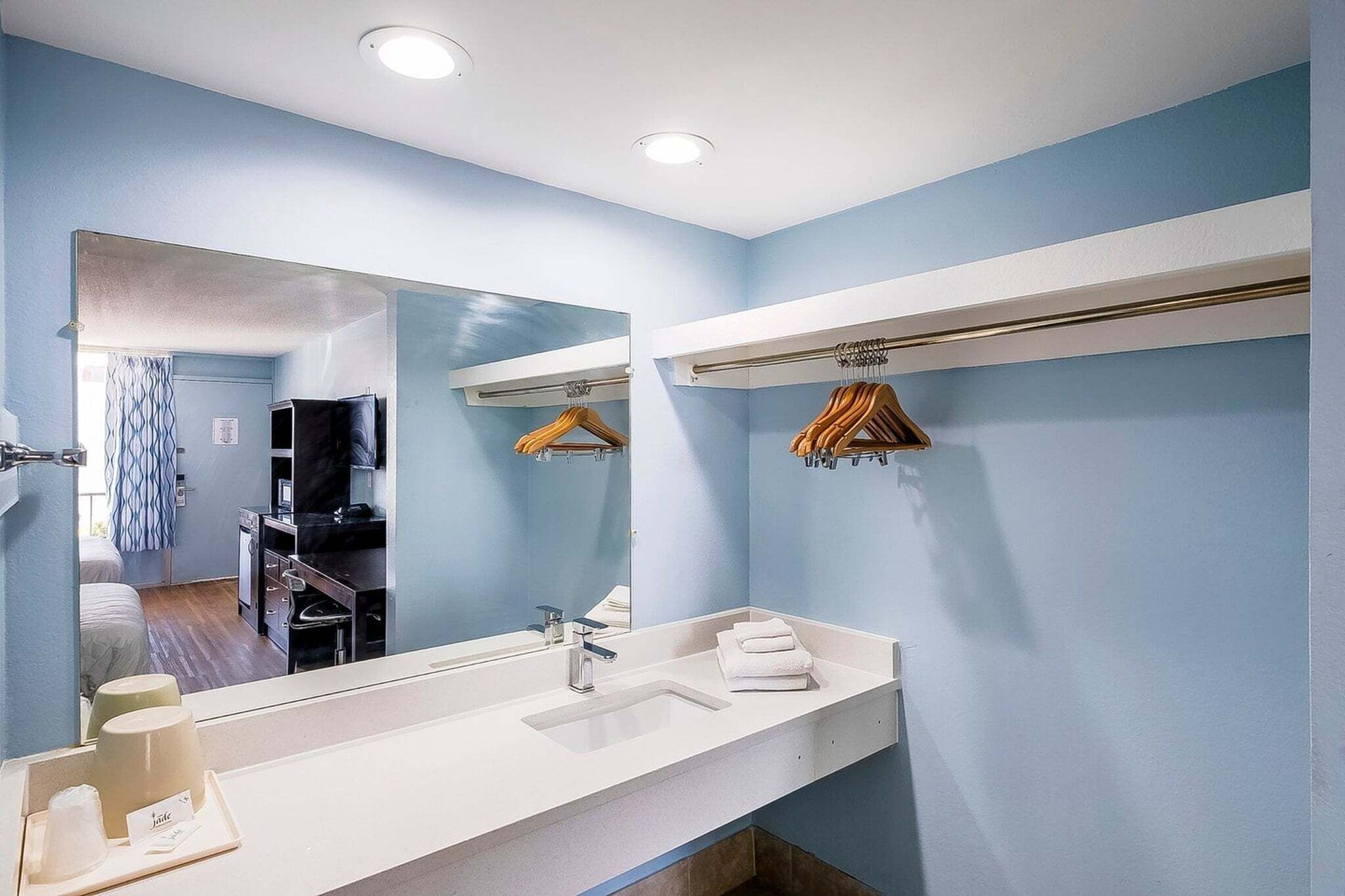 Een moderne badkamer met een grote spiegel, een wastafel en een handdoekrek.