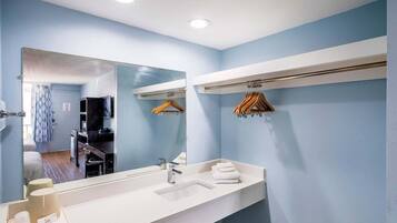 Een moderne badkamer met een grote spiegel, een wastafel en een handdoekrek.