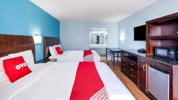 Une chambre d’hôtel avec deux lits, un bureau, un four à micro-ondes et un réfrigérateur.