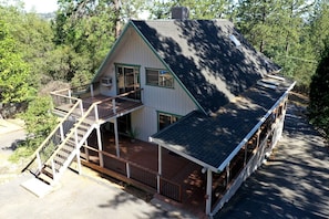 A two-story house with a balcony, a covered porch, and a chimney.