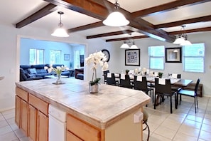 A spacious kitchen with a large island, wooden cabinets, and pendant lighting.