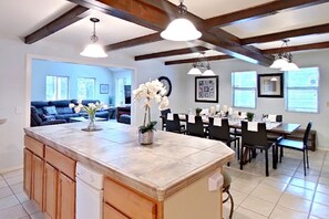 A spacious kitchen with a large island, wooden cabinets, and pendant lighting.