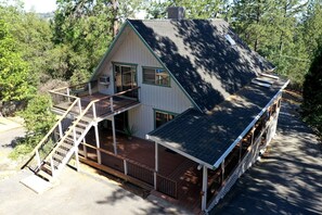 A two-story house with a balcony, a covered porch, and a chimney.