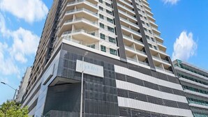 En hög byggnad med många våningar, stora fönster och en modern arkitektonisk design.