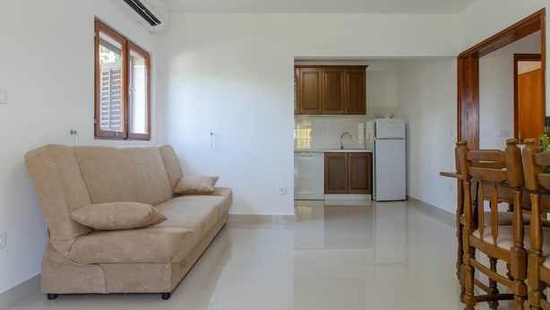 Ein Wohnzimmer mit einer Couch und einem Esstisch mit Stühlen.