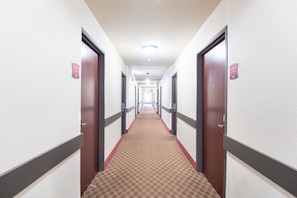 Passadís d'hotel amb portes que porten la inscripció 'Texas' i el número 211.