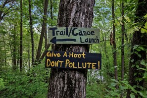 Un cartel de sendero con indicaciones y un mensaje sobre el cuidado del medio ambiente.