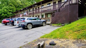 Un motel doté d’un parking couvert, d’un escalier menant à l’entrée et d’un bâtiment avec un balcon.