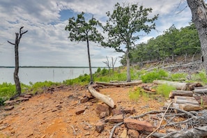 A natural landscape with a lake, trees, and a rocky shoreline.