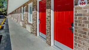A row of red doors with a sign indicating room number 104.