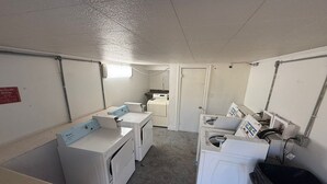 Une buanderie équipée d’un lave-linge, d’un sèche-linge et d’un évier utilitaire.