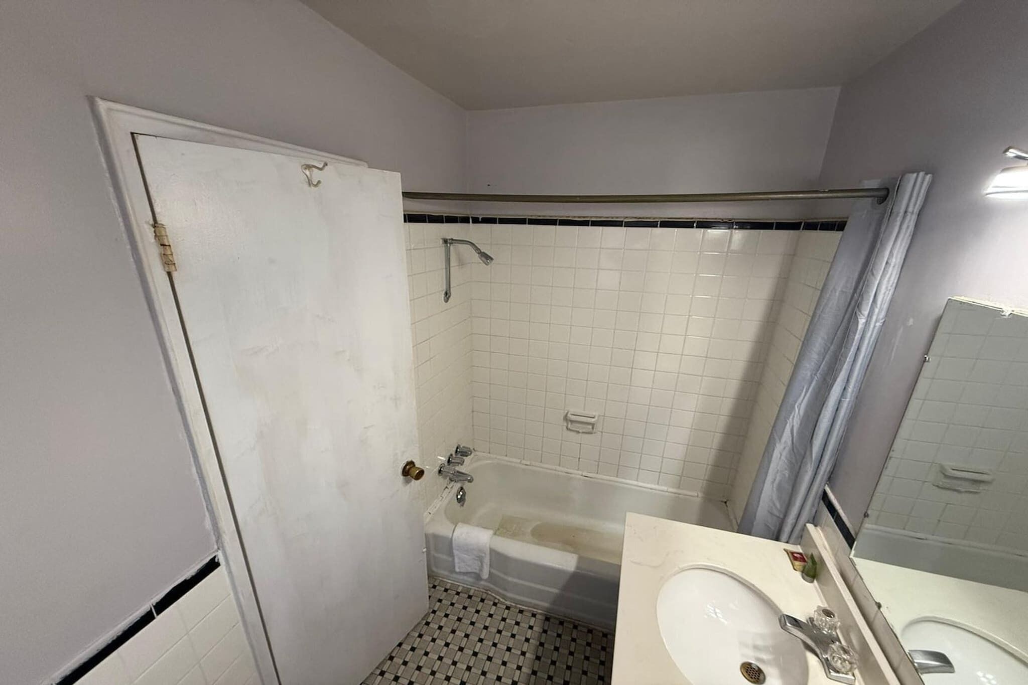 A bathroom with a bathtub, a shower, a sink, and a mirror.