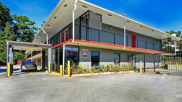 A two-story building with a covered entrance, a visible address number, and a gated parking area.