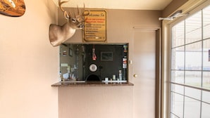 Ett entrérum med en hjorthuvuddekoration, en välkomstskylt, en receptionsdisk och ett fönster med utsikt.