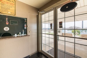 En hotellobby med en glasdörr, en receptionsdisk och en skylt som listar vilka betalningskort som accepteras, till exempel American Express, MasterCard och Visa.