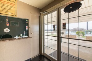 En hotellobby med en glasdörr, en receptionsdisk och en skylt som listar vilka betalningskort som accepteras, till exempel American Express, MasterCard och Visa.