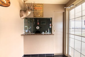 A reception area with a deer head decoration, a welcome sign, a counter, and a window with a view.