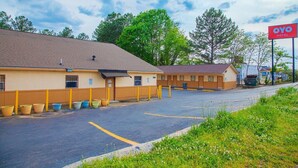 A motel with a parking lot, a sign for OYO Hotel, and a building with a brown roof. - Premium Queen Bed|Non-Smoking (Decatur GA)