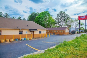 A motel with a parking lot, a sign for OYO Hotel, and a building with a brown roof. - Queen Bed|Non-Smoking (Decatur GA)