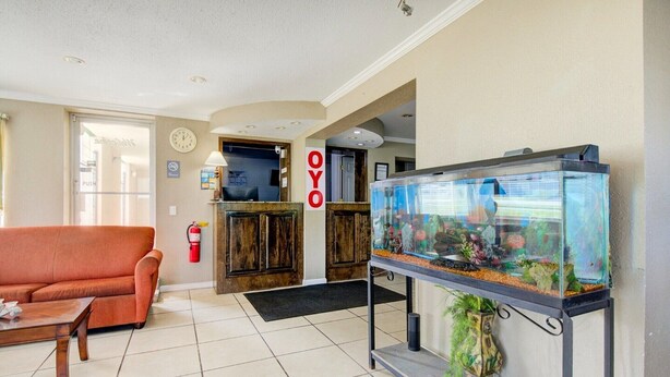 Eine Lobby mit einer Rezeption, einer Couch, einem Aquarium und einem Feuerlöscher.