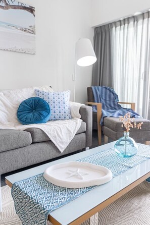En stue med en sofa, en lænestol, et sofabord og en lampe.