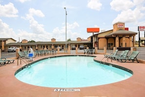 A hotel with a swimming pool, outdoor seating, and a sign indicating no diving. - King Bed | Smoking|Texarkana TX (Texarkana TX)