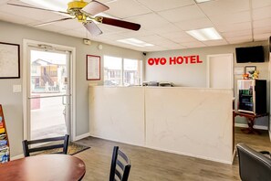 A reception area with a desk, chairs, a ceiling fan, and a view of the outside. - King Bed | Smoking|Texarkana TX (Texarkana TX)