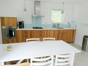 A modern kitchen with wooden cabinets, a white countertop, a gas stove, and a stainless steel sink. - Park Retreat With Fireplace (Koudekerke)
