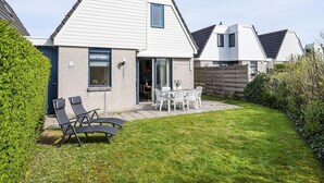 A modern house with a patio, a dining area, and a small garden. - Home With Dune Views in Zeeland (Vlissingen)