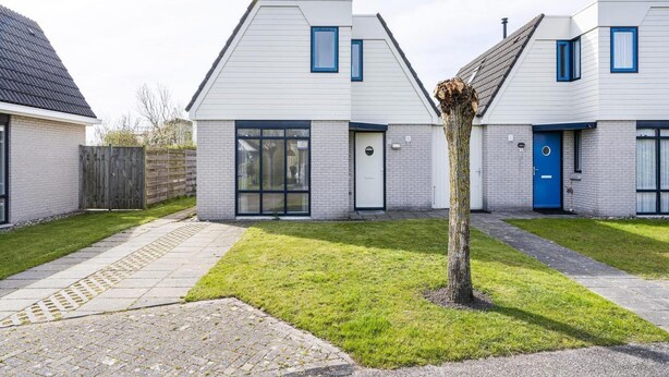 A modern residential building with a symmetrical design, featuring a central tree, a paved pathway, and a well-maintained lawn. - Home With Dune Views in Zeeland (Vlissingen)
