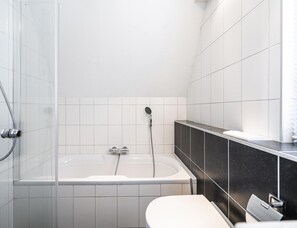 Ein modernes Badezimmer mit Badewanne, Dusche und Toilette.