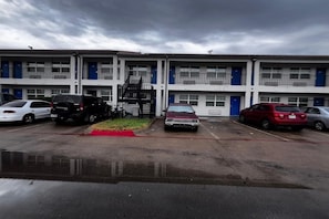A multi-story motel with a parking lot.