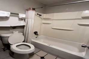 A bathroom with a toilet, a bathtub, and a shower curtain.