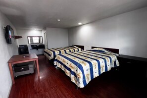 A hotel room with two beds, a desk, a television, and a small kitchenette. - 2 Queen Bed|Smoking|Dallas (Dallas)