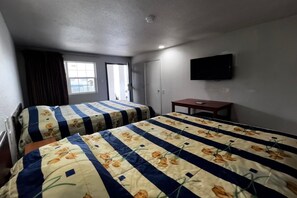 A bedroom with two beds, a TV, a small table, and a window with curtains. - 2 Queen Bed|Smoking|Dallas (Dallas)