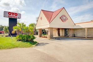 A hotel with a prominent 'OYO HOTEL' sign, a 'WILD FIRE' logo, and a covered entrance with a parking lot.