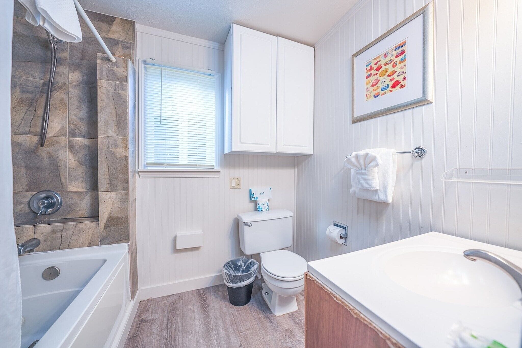 A bathroom with a bathtub, toilet, and sink.