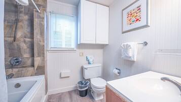 A bathroom with a bathtub, toilet, and sink.