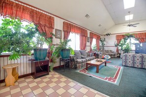 A living room with striped walls, a ceiling fan, and multiple pieces of furniture including sofas and a coffee table.