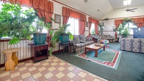A living room with striped walls, a ceiling fan, and multiple pieces of furniture including sofas and a coffee table.